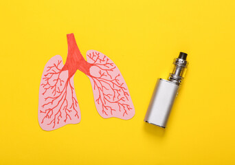 Harm of smoking on lung health concept. Anatomical lungs and vaping device on yellow background