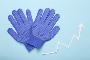 Work gloves with a growth arrow on a blue background. Top view