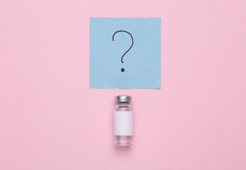 Medicine concept. Vaccine bottle with a question mark on a memo paper on a pink background. Top view