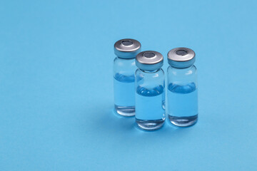Glass vaccine bottles on a blue background