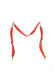 Letter M made from red chilli peppers isolated on white background
