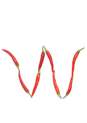 Letter W made from red chilli peppers isolated on white background