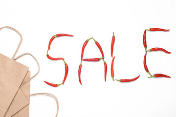 Word sale made from red chili peppers and shopping paper bags isolated on white background. Shopping concept