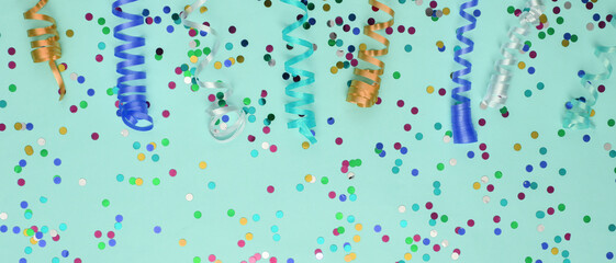 Colored streamer and confetti on mint, green background. Holiday, birthday background