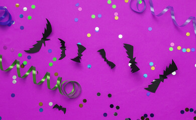 Halloween decor with colored streamer with confetti on pink background. Halloween celebration, fun and fear. Top view. Flat lay