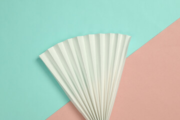 Paper fan on blue-pink pastel background. Concept art, minimalism