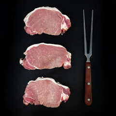 Tenderloin fillet mignon and meat fork on on dark background copy space, top view, overhead, flat...