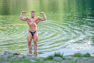 male bodybuilder in the water in nature