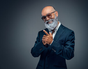 Shot of happy elderly businessperson with beard and sunglasses dressed in stylish suit.