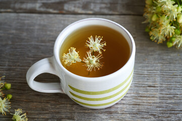 A cup of herbal tea with linden flowers in spring