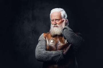 Portrait of thoughtful antique aged warrior dressed in chain mail and leather armor.