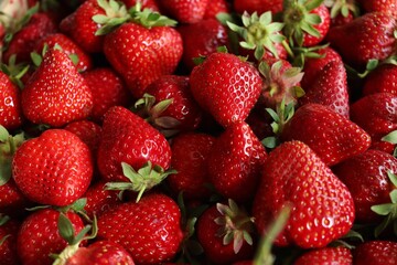 Top view of fresh red strawberries with green leaves. Berry basket. Berry background. Grocery store showcase. Menu of fresh berries and fruits. Grocery background. Bright colors. Red and green.