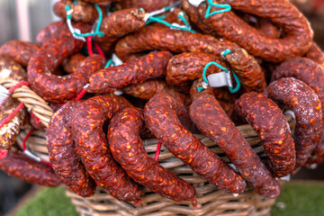 Stacks of dry-cured sausages - saucisson, typically made of pork, or a mixture of pork and other meats. Some variation contains spices and herbs, mushrooms, dried fruits, nuts, or cheese.