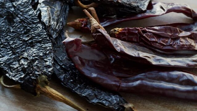 Dried chili peppers: Guajillo, Ancho and Pasilla close-up. Table spin.