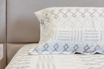Hotel room. Detail in pillow and bedding with geometric pattern.