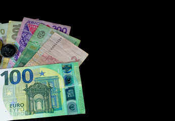One hundred euro banknote and Ukrainian hryvnia close up on a black background with empty space
