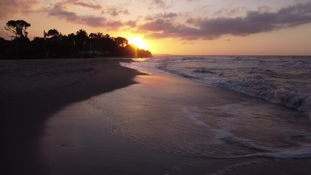Aerial, sunset at the beach, a drone shot over a beach, small waves, Corozal, Honduras.