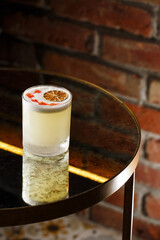 Pisco sour cocktail - whiskey with lime, egg white, sugar syrup in glass on dark background. Space for text