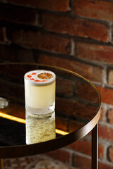 Pisco sour cocktail - whiskey with lime, egg white, sugar syrup in glass on dark background. Space for text