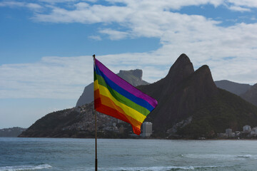 Rio de Janeiro, Brazil. Gay flag fluttering. Ipanema beach sea and two brothers hill in the background.
