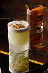 Pisco sour cocktail - whiskey with lime, egg white, sugar syrup in glass on dark background. Space for text