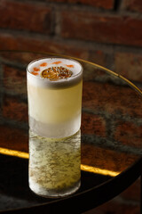 Pisco sour cocktail - whiskey with lime, egg white, sugar syrup in glass on dark background. Space for text