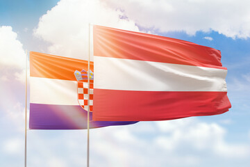 Sunny blue sky and flags of austria and croatia
