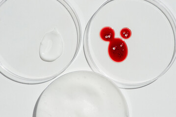 Cosmetic swatches. Appearance of the texture of the cream, red mask and granules in petri dishes on...