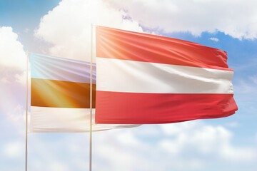 Sunny blue sky and flags of austria and estonia