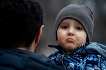 dad holds an upset baby in his arms