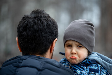 Obraz premium dad holds an upset baby in his arms