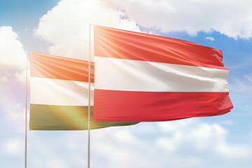 Sunny blue sky and flags of austria and hungary