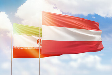 Sunny blue sky and flags of austria and iran