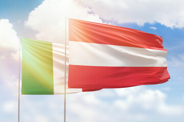 Sunny blue sky and flags of austria and italy