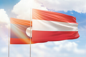 Sunny blue sky and flags of austria and laos