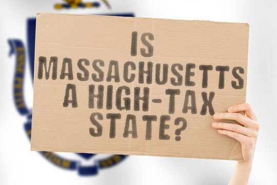 The question " Is Massachusetts a high-tax state? " is on a banner in men's hands with blurred background. Cost. Budget. Crisis. Decision. Earnings. Freedom. Interest. Revenue
