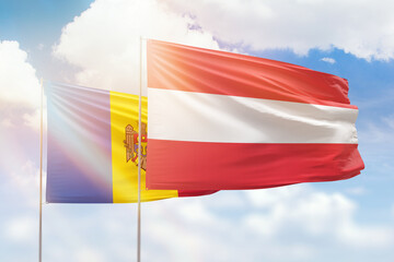 Sunny blue sky and flags of austria and moldova