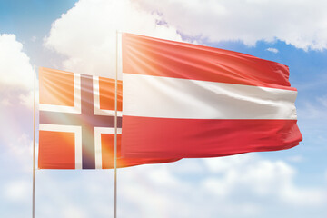 Sunny blue sky and flags of austria and norway