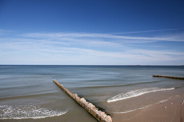 Calm sea surface and sky. Beautiful coastline and breakwaters. Baltic Sea.