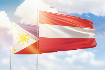 Sunny blue sky and flags of austria and philippines