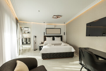 Interior of a luxury double bed hotel bedroom with black and white furniture