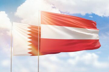 Sunny blue sky and flags of austria and qatar
