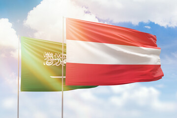 Sunny blue sky and flags of austria and saudi arabia