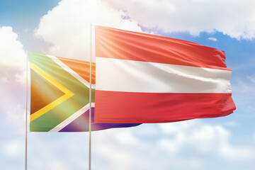 Sunny blue sky and flags of austria and south africa