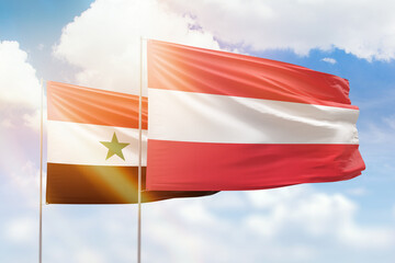 Sunny blue sky and flags of austria and syria