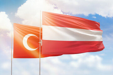 Sunny blue sky and flags of austria and turkey