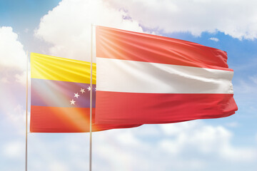 Sunny blue sky and flags of austria and venezuela