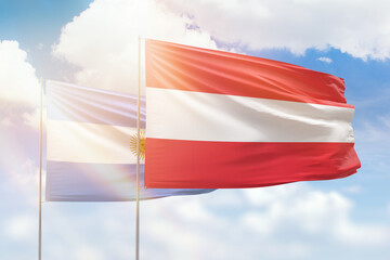 Sunny blue sky and flags of austria and argentina