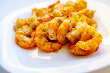 Fried large peeled shrimp with spices on a white plate