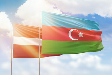 Sunny blue sky and flags of azerbaijan and latvia